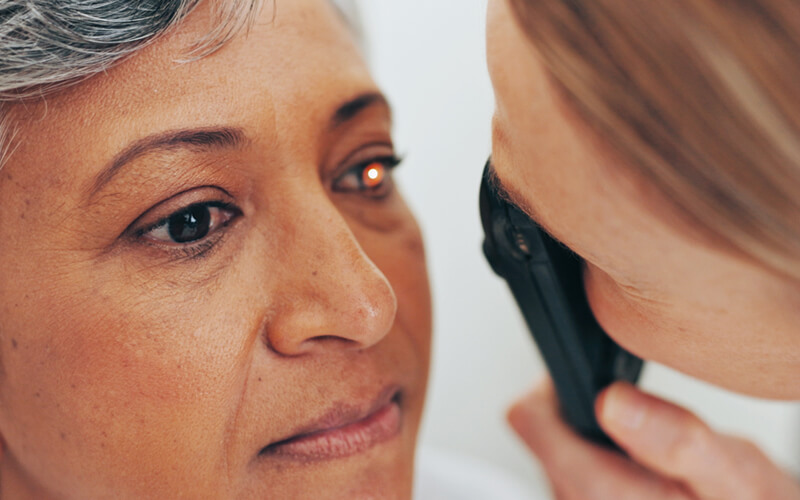 An Eye Doctor examining a dilated eye to determine the cause of new flashes or floaters