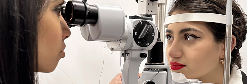 Dr. Harina examining a patient's eye with a slit lamp