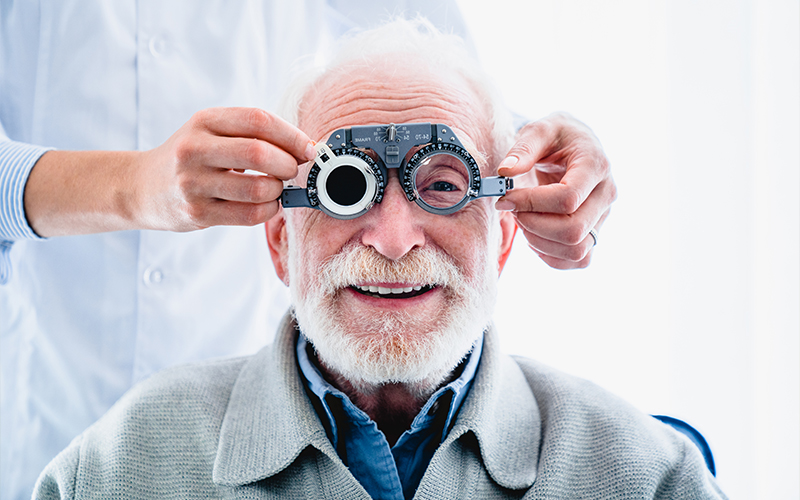 An optometrist using a phoropter during a comprehensive eye examination