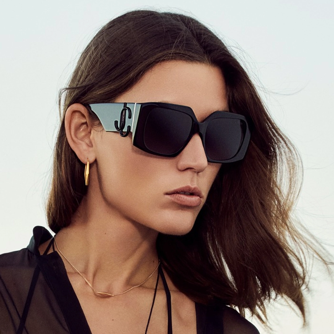 Une femme exhibant de glamoureuses lunettes de soleil Jimmy Choo aux détails scintillants.